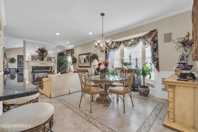 dining space featuring a notable chandelier, crown molding, and a premium fireplace