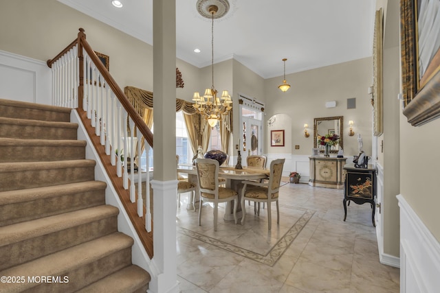 dining area with a towering ceiling, ornamental molding, and a chandelier