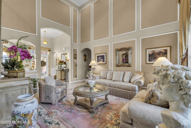 living room featuring crown molding and a high ceiling