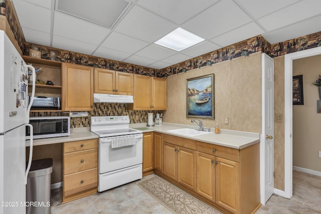 kitchen with sink, white appliances, a paneled ceiling, and light tile patterned floors