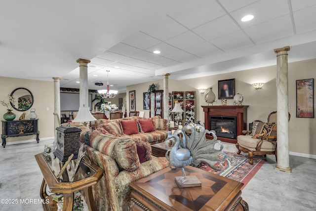 living room featuring a drop ceiling and ornate columns