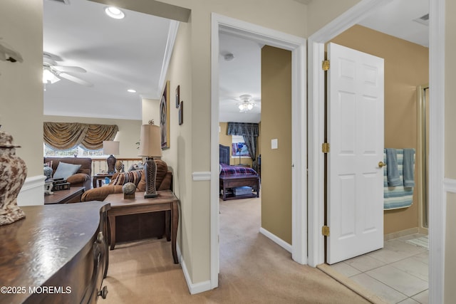 hall with ornamental molding and light colored carpet