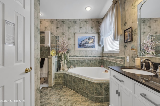 bathroom featuring vanity, independent shower and bath, tile patterned flooring, and tile walls