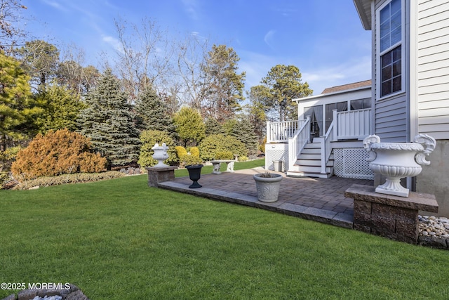 view of yard with a sunroom, a deck, and a patio area