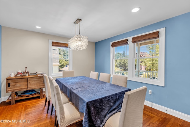 dining area with an inviting chandelier and parquet floors