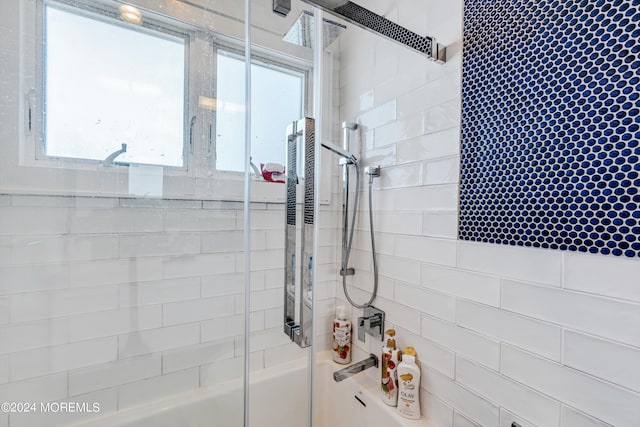 bathroom with bath / shower combo with glass door