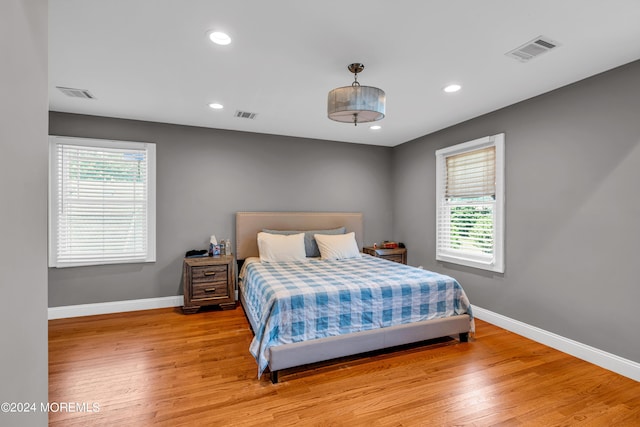 bedroom featuring multiple windows and light hardwood / wood-style flooring