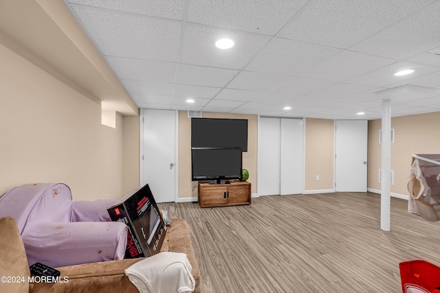 living room featuring a paneled ceiling and hardwood / wood-style floors