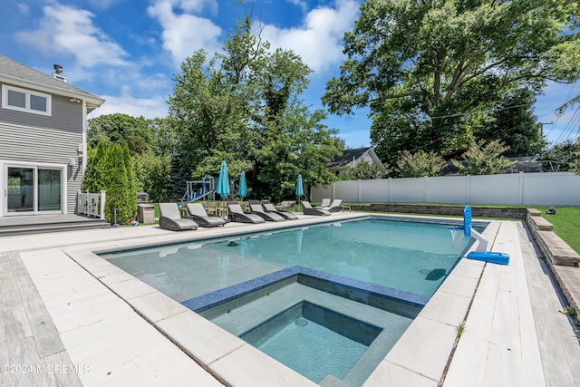 view of swimming pool featuring an in ground hot tub