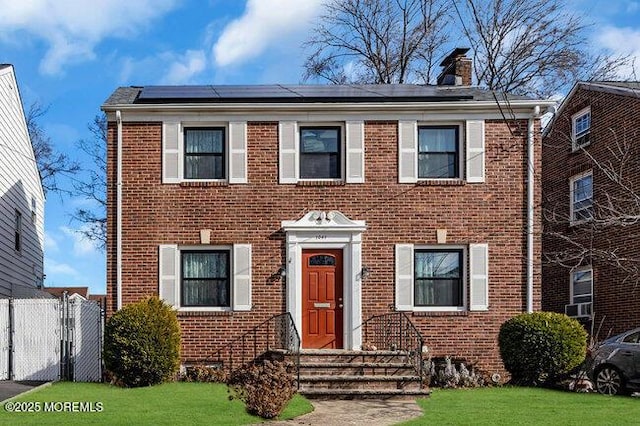 view of front of house featuring a front yard and solar panels