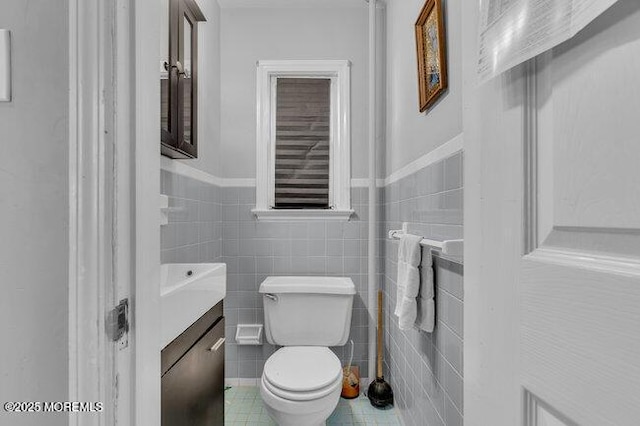 bathroom with vanity, tile walls, and toilet