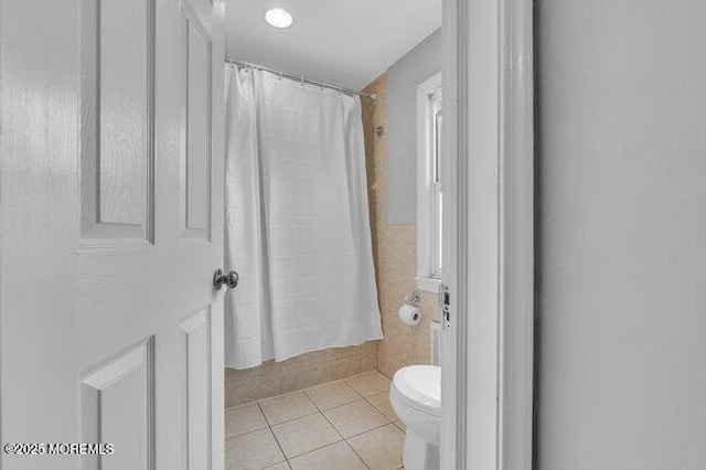 bathroom featuring tile patterned floors, toilet, and curtained shower