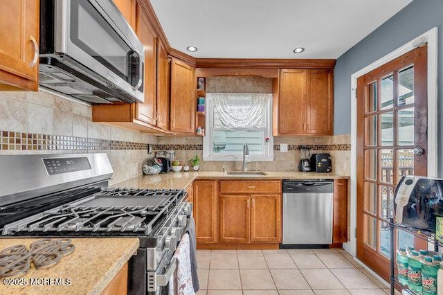 kitchen featuring backsplash, stainless steel appliances, sink, and light tile patterned floors