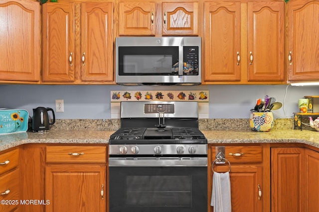 kitchen featuring light stone counters and appliances with stainless steel finishes