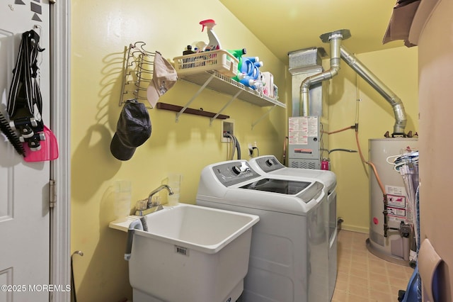 clothes washing area with water heater, washing machine and dryer, and sink