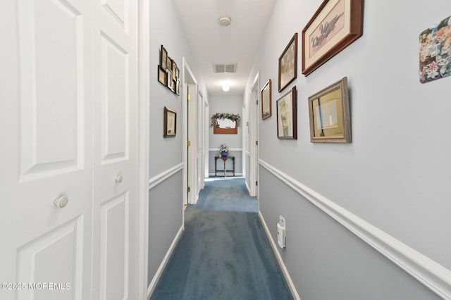 corridor featuring dark colored carpet