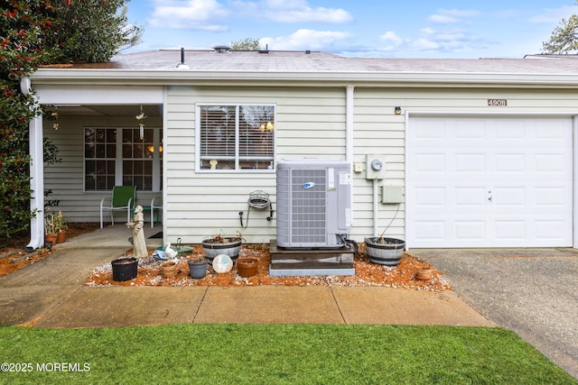 single story home featuring cooling unit and a garage