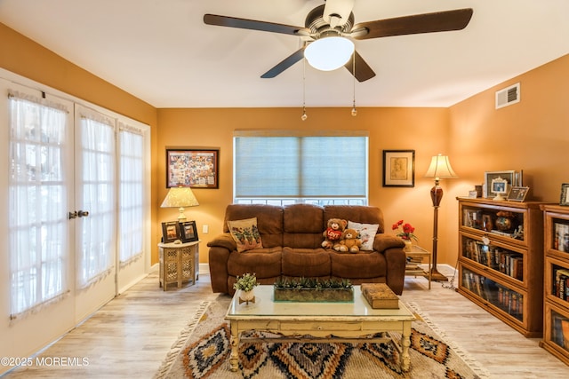 living room with plenty of natural light, ceiling fan, and light hardwood / wood-style flooring