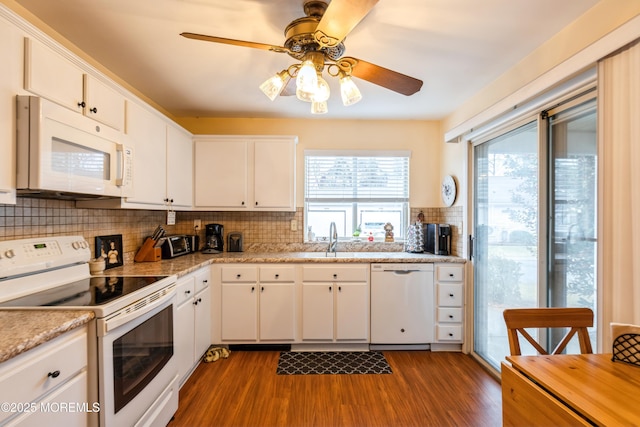 kitchen with white appliances, dark hardwood / wood-style flooring, sink, and white cabinets