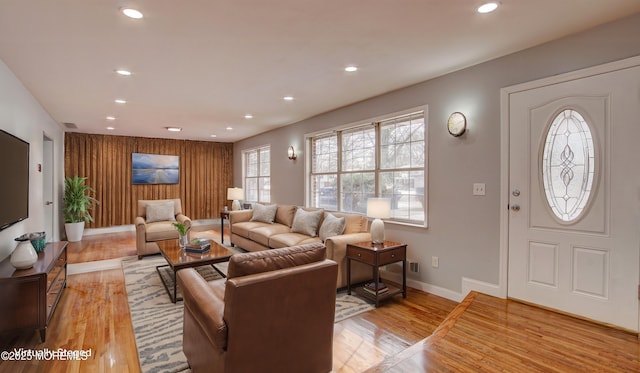 living room with recessed lighting, light wood-type flooring, baseboards, and visible vents