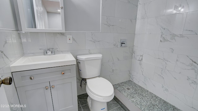 bathroom featuring tiled shower, toilet, and vanity