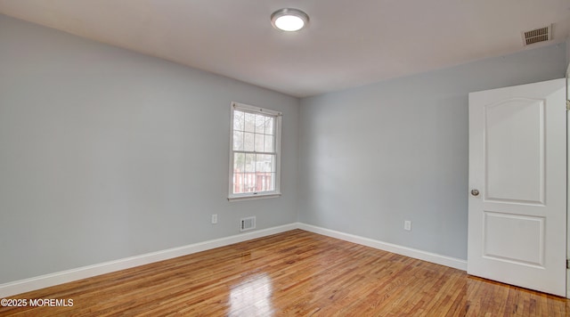 spare room featuring visible vents, baseboards, and light wood finished floors