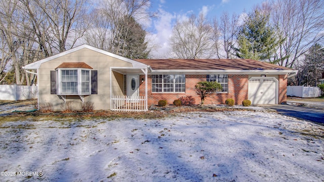 ranch-style house featuring driveway, brick siding, an attached garage, and fence