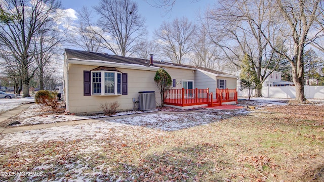 back of property with central AC unit, a wooden deck, and fence