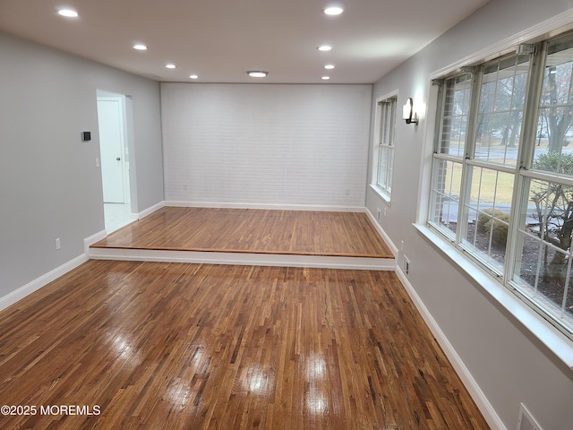 empty room with visible vents, recessed lighting, baseboards, and wood-type flooring