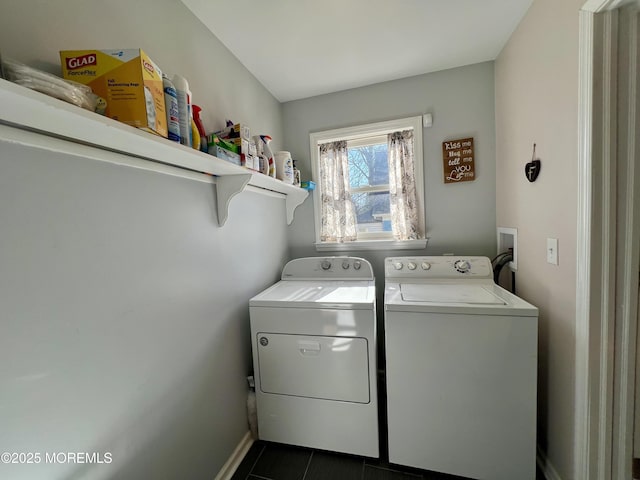 clothes washing area with washer and dryer and dark tile patterned floors