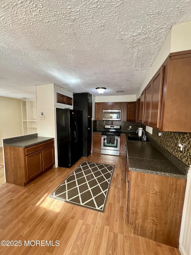 kitchen featuring stainless steel appliances, sink, light hardwood / wood-style floors, and decorative backsplash