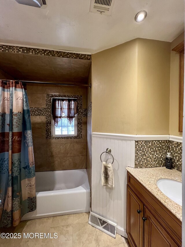 bathroom with vanity, shower / bathtub combination with curtain, and tile patterned flooring