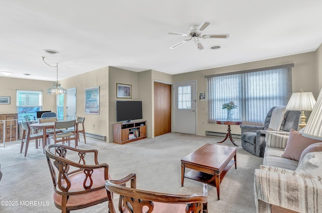 living room with ceiling fan with notable chandelier, a baseboard heating unit, and light colored carpet