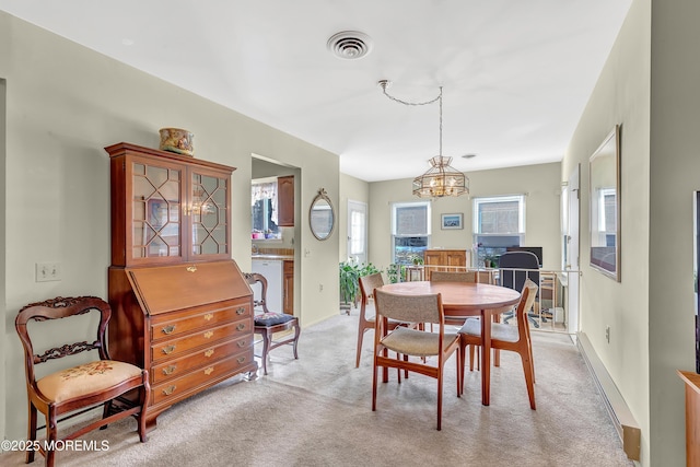 carpeted dining space featuring a chandelier