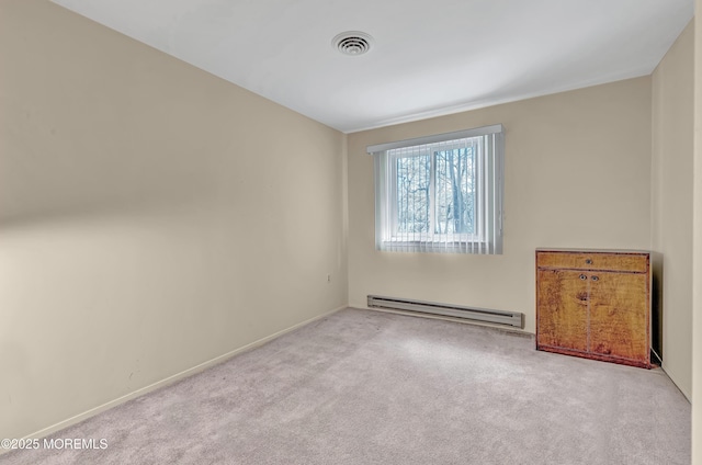 spare room with light colored carpet and a baseboard heating unit