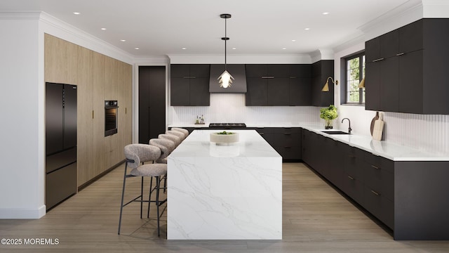 kitchen featuring a breakfast bar, sink, hanging light fixtures, ornamental molding, and a kitchen island