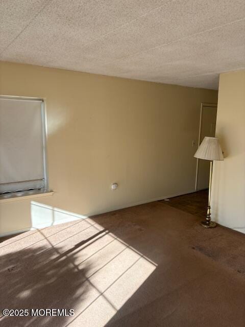 unfurnished living room featuring carpet flooring and a textured ceiling