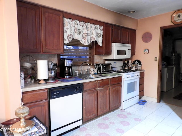 kitchen featuring white appliances, sink, and light tile patterned floors