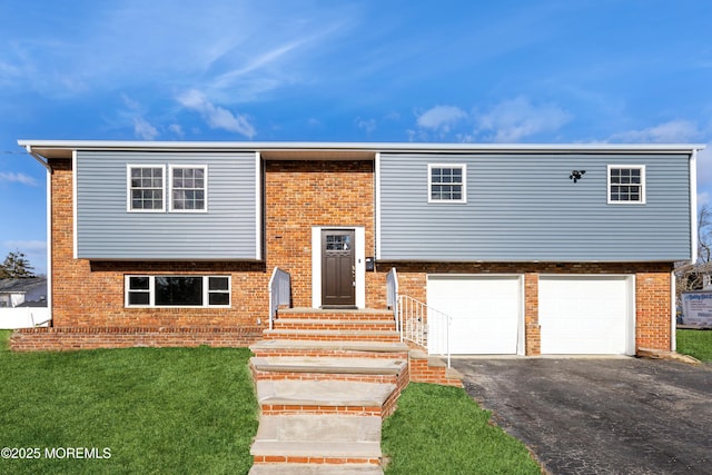 raised ranch featuring a garage and a front yard