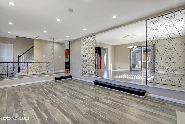 workout room with wood-type flooring and a notable chandelier