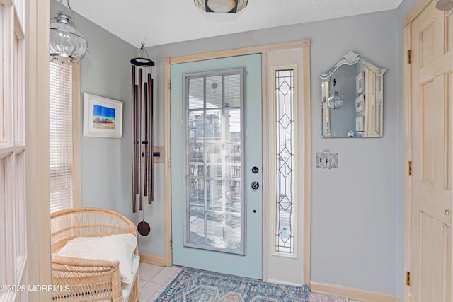 foyer featuring light tile patterned floors and a textured ceiling