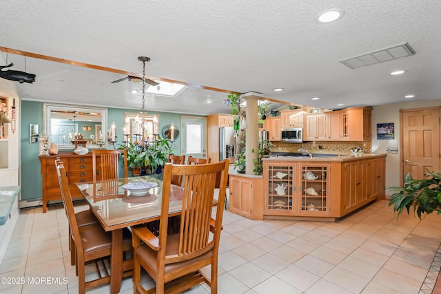 tiled dining area featuring a baseboard heating unit, a chandelier, and a textured ceiling