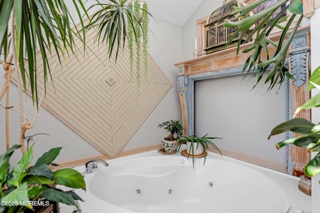 bathroom with vaulted ceiling, a tub, and a textured ceiling