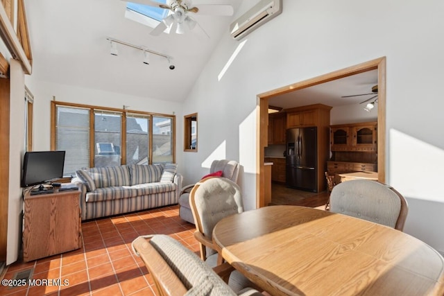 tiled dining room featuring an AC wall unit, high vaulted ceiling, a skylight, ceiling fan, and track lighting