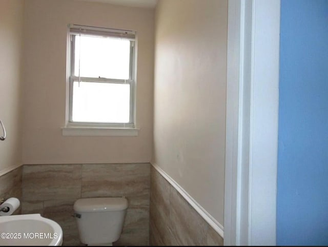 bathroom featuring tile walls, plenty of natural light, and toilet