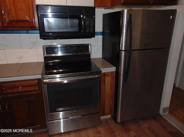 kitchen with tasteful backsplash, appliances with stainless steel finishes, and dark hardwood / wood-style floors