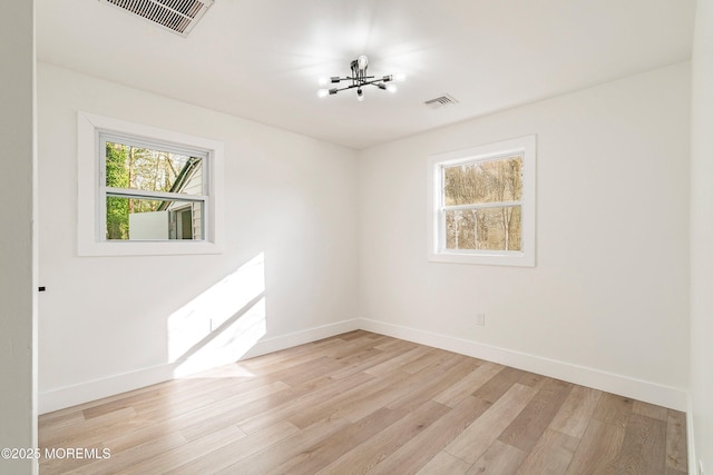 unfurnished room featuring a healthy amount of sunlight and light hardwood / wood-style floors