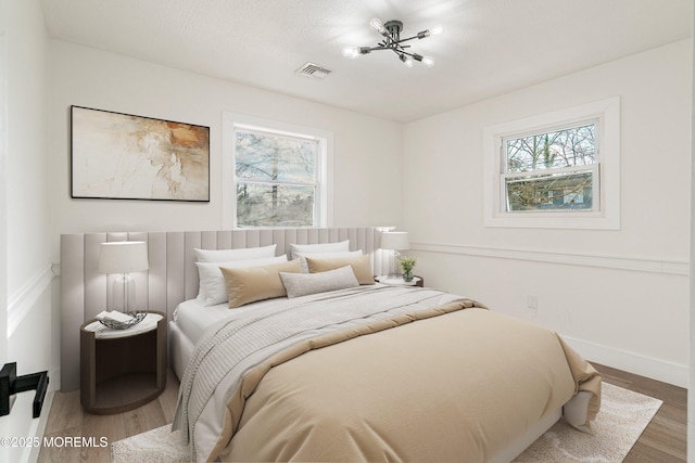 bedroom with hardwood / wood-style floors and multiple windows