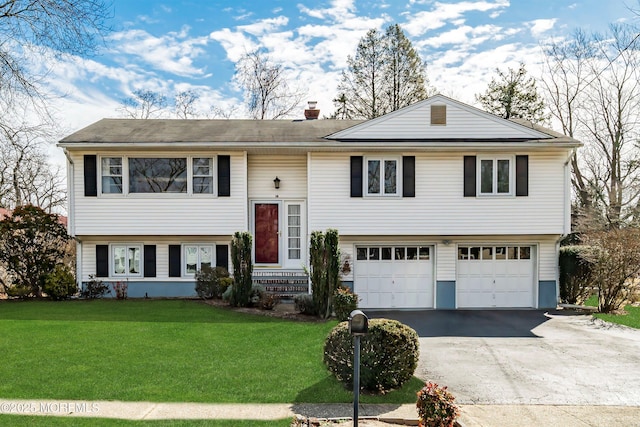 bi-level home with driveway, entry steps, a garage, a chimney, and a front yard