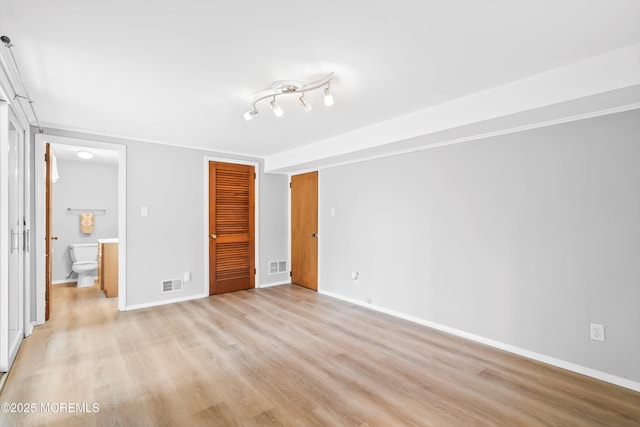 unfurnished bedroom featuring a closet, visible vents, and light wood-style floors